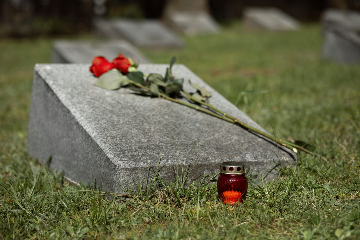 A memorial plaque with roses and a candle